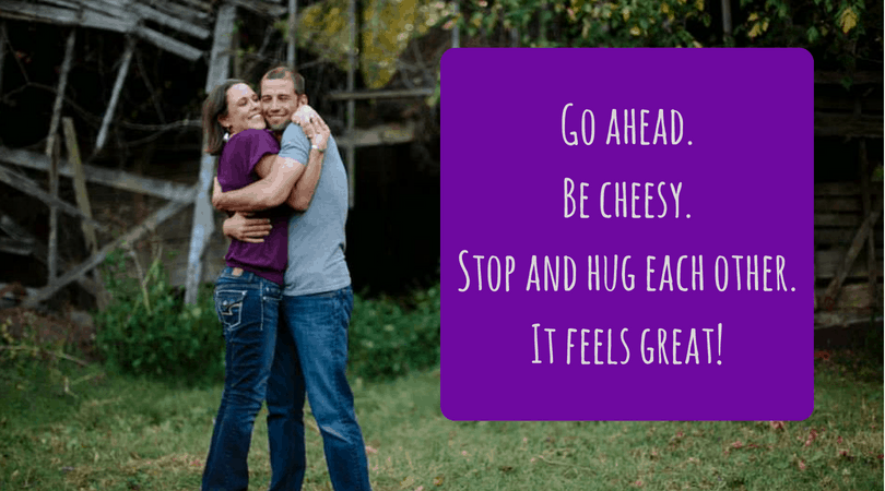 A couple hugs with text next to them that says "Go ahead. Be cheesy. Stop and hug each other. It feels great!"