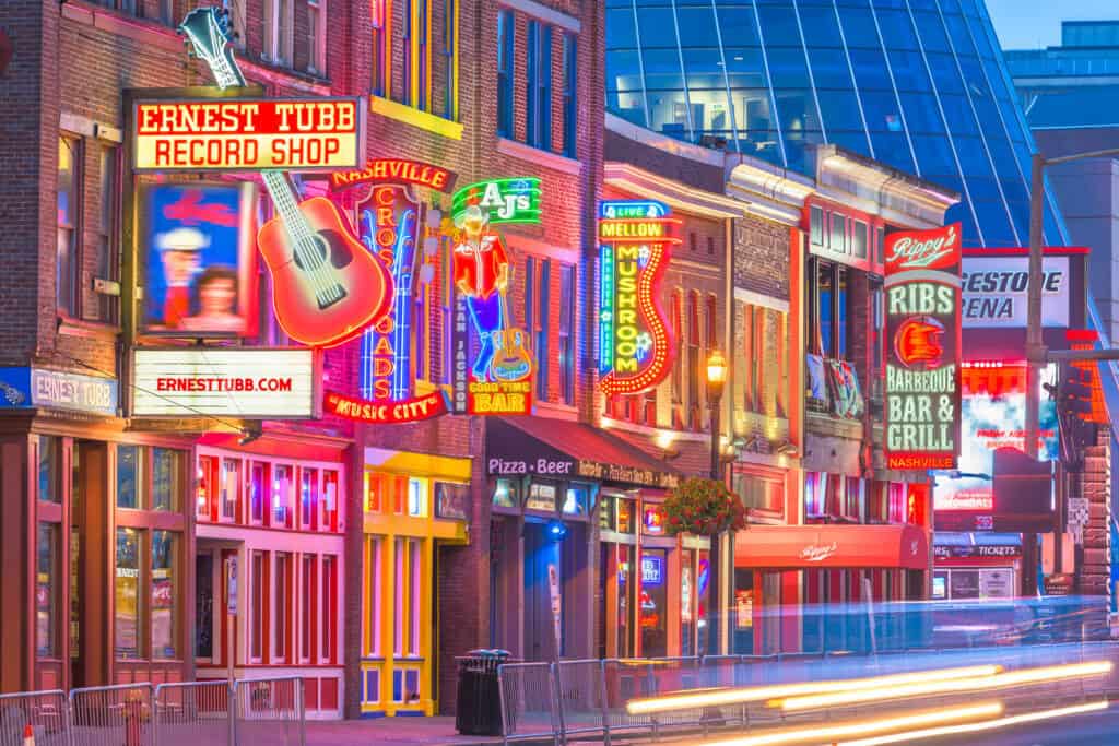 Street lined with shops featuring neon signs.