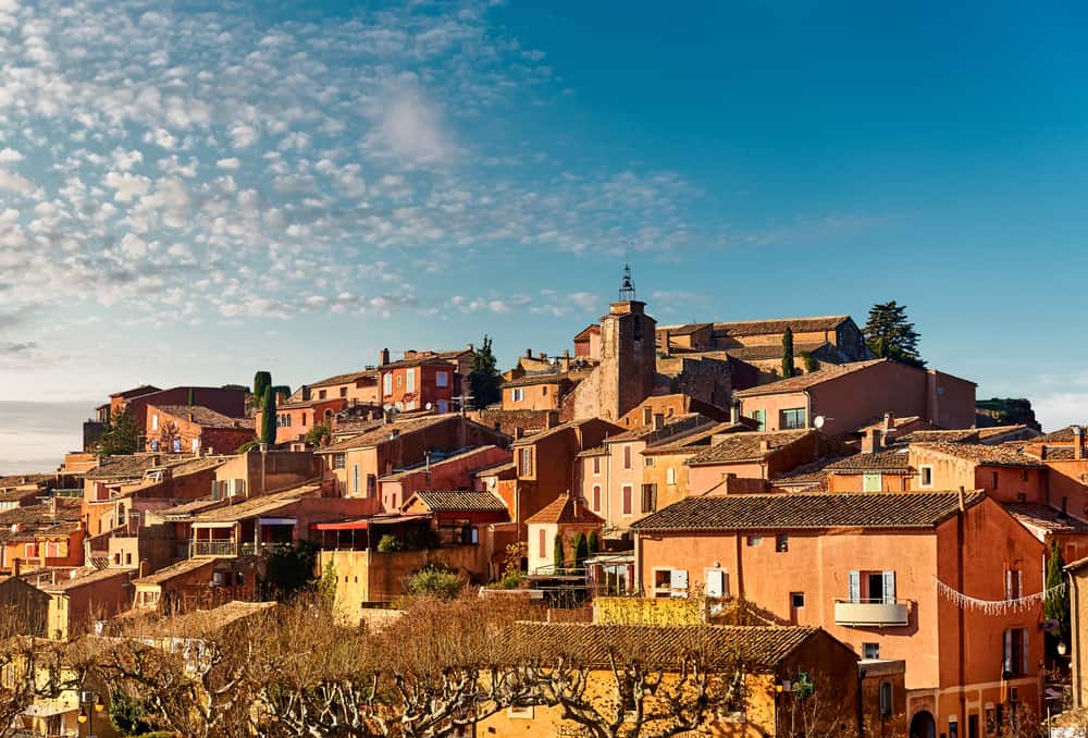 Aerial view of a city filled with orange and peach colored buildings on a sunny day. 